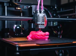 GTA 6 Fans 3D Print Macca the Gator Figure Following $400 Collector’s Box Reveal A 3D printer creating a neon-colored alligator figure.