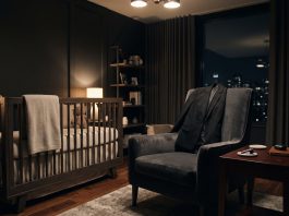 A cinematic conceptual scene of a professional blazer and earpiece in a luxury nursery setting.