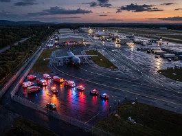 Conceptual aerial view of an airfield with emergency response lights at twilight.