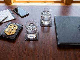 A police captain's badge and a legal consultant's portfolio on a desk.