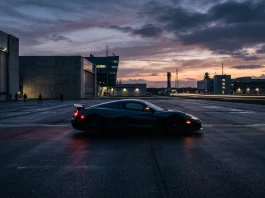 Conceptual image of a high-performance electric sports car near an aerospace facility.