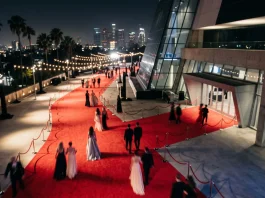A high-angle conceptual view of a glamorous red carpet event at night.