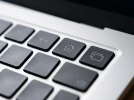 Close-up of a minimalist laptop keyboard showing navigation symbols on the function keys.