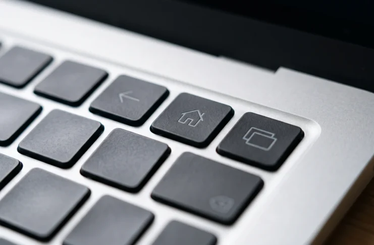 Close-up of a minimalist laptop keyboard showing navigation symbols on the function keys.
