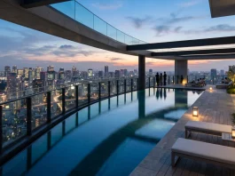 A luxury infinity pool with views of a city skyline at sunset.