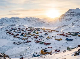 A conceptual landscape of a remote Arctic town with colorful buildings and snowy mountains.