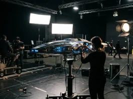 A miniature model of a starship on a film set under studio lights.